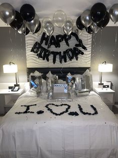 a birthday cake on a table with balloons and streamers in the shape of an i love you sign