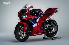 a red, white and blue motorcycle is shown in front of a gray background with the words honda on it