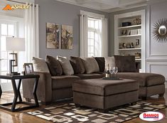 a living room filled with furniture on top of a hard wood floor covered in rugs