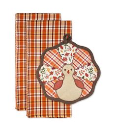 two napkins with an embroidered turkey on the front and plaid pattern in the back