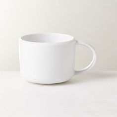 a white coffee cup sitting on top of a table