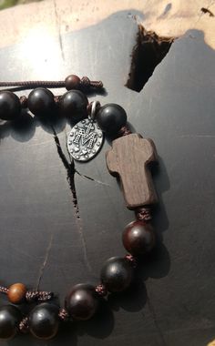 +. This is a Wooden Rosary Bracelet. +.It is knotted bracelet and it is adjustable . +.The crufix is carved in elevorate and three dementional shape. +.+.+.+.+. Materials +.+.+.+.+.+. Cross: Mpingo(Africa black wood) Beads : black wood +.+.+.+.+. Size +.+.+.+.+. Cross : 13.3mm(Width) *20mm(Height) Beads: 8mm +. Carved characters(e.g. baptismal name, name,etc) on back side +. please send me characters that you want. It's Free engraving +.Lead time is 3-7 business days. +.Delivery is currently bei Adjustable Brown Hand-strung Rosary, Adjustable Wooden Beads Rosary Bracelet Gift, Adjustable Wooden Bead Rosary Bracelet Gift, Spiritual Brown Rosary Bracelet For Gift, Adjustable Wooden Beads Jewelry For Blessing, Handmade Brown Rosary Bracelet As Gift, Jujube Tree, Bracelet Rosary, Knotted Rosary