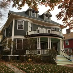 an old victorian house with two stories and a wraparound porch