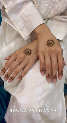 two hands with henna tattoos on them