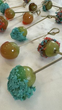 some green and blue cake pops are sitting on a table