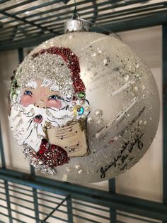 a christmas ornament hanging from the side of a metal rack with writing on it