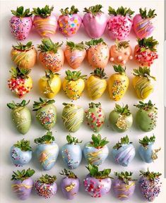 there are many different types of strawberries on the white table and one is decorated with sprinkles