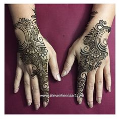 two hands with henna tattoos on them