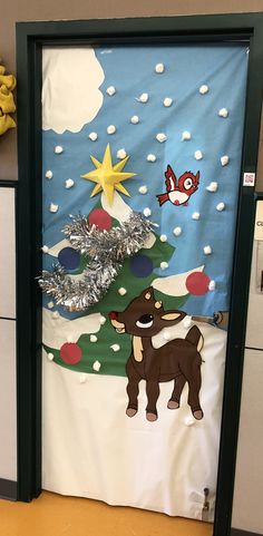 a door decorated with a christmas tree and reindeer