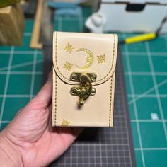 a hand holding a small wallet on top of a table