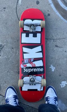 the skateboard is red and black with white letters on it's bottom part