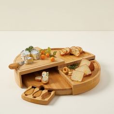 an assortment of cheeses and bread in a wooden tray