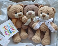 two crocheted teddy bears sitting next to each other on top of a piece of paper