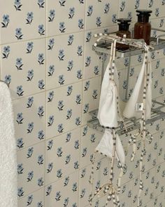 a towel rack in the corner of a bathroom with blue and white tiles on it