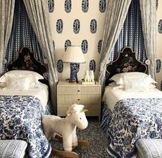 two beds in a room with blue and white decor on the walls, one has a rocking horse