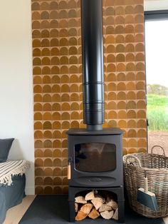 a wood burning stove sitting next to a pile of firewood in a living room