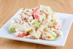 a white plate topped with pasta salad on top of a wooden table