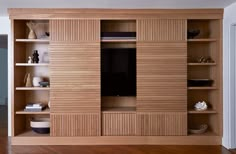 an entertainment center with wooden shelves and shelving