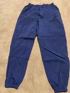 These vintage Nike track pants joggers are in excellent condition. They are a size XL and have a drawstring waist and zip up around the ankles with elastic at the ankles as well . Smoke free home.  Zippered back pockets and 2 side pockets.  Wrinkly material and not soft sweatpant material.  Rise about 14"  Inseam about  33"  Waist about 15" with an elastic waistband as well as drawstring. Nike Navy Bottoms For Streetwear, Sporty Blue Ankle-length Pants, Vintage Nike Track Pants, Windbreaker Track Pants, Blue Windbreaker, Nike Track Pants, Mens Vintage, Nike Blue, Jogger Sweatpants