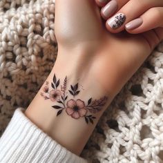 a woman's wrist tattoo with flowers on it