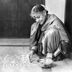 a woman is sitting on the floor and drawing with her hands in front of a bowl