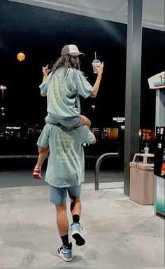 a man holding a young child in his arms while walking through an airport parking lot