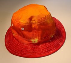 "This is another great sun hat. Cameo brand, medium to large size hat. Has about a 23\" finished size after shrinking. It did shrink about an inch during the dying process. Hats may stretch back to their original size. This hat is orange with non-cotton white stitching." Floral Bucket Hat, Stretch Back, Crochet Bucket Hat, Custom Paint Jobs, Cloth Napkin, Custom Ties, Pink Swirls, Tie Dyed, Sun Hat