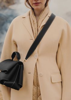 The "Mokki" model showcases the art of folding with its textured leather. The corners are cut to reveal smooth leather for a subtle interplay of textures. The bag’s interior is roomy and divided into compartments, all protected by a flap that features an engraved clasp. With its adjustable shoulder strap held in place by snap hooks, the model smoothly adapts to your movements. Micro Bags, Best Wallet, Black Textures, Small Leather Goods, Smooth Leather, Bags Designer, Shoulder Strap, Bag Lady, Texture