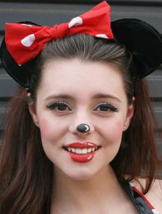 a girl wearing minnie mouse ears and red lipstick