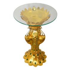 a glass and gold plate with a peacock design on the base, sitting on a white background