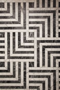 a black and white marble floor with an abstract design in the center that looks like a maze