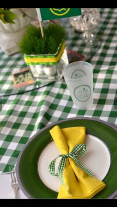 a green and white checkered table cloth with a yellow napkin tied around the edge