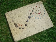 a stone with rocks on it laying in the grass