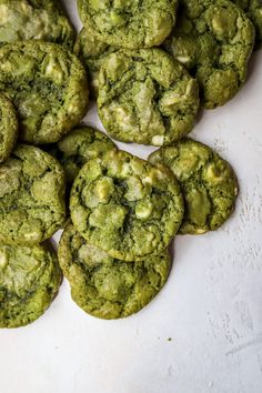 some green cookies are on a white surface