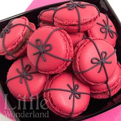 pink macaroons in a black box on a table