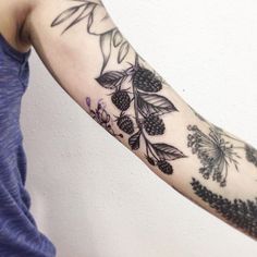 a woman's arm with flowers and leaves tattooed on the left side of her arm