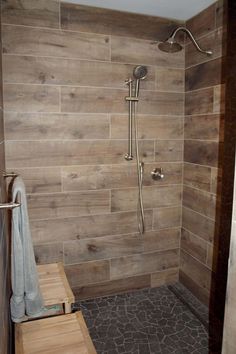 a walk in shower sitting next to a wooden bench