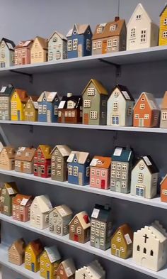 several shelves filled with small houses on top of each other