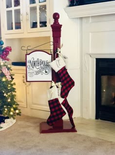 stockings are hanging from a pole in front of a fireplace with a sign that says north pole