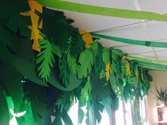 a room with green and yellow decorations hanging from the ceiling in front of a window