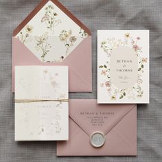 the wedding stationery is laid out on top of each other, including two envelopes