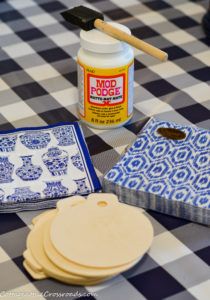 the table is covered with blue and white checkered cloths, plates, and paint