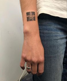 a person with a small tattoo on their left wrist and the other hand is holding an object