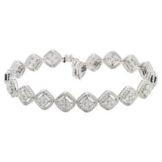 Elegance meets high-end style in this exquisite diamond halo bracelet, crafted from 18KT white gold. This luxurious piece features shimmering square cushion clusters of round-shaped diamonds, each cluster encircled by a dazzling halo setting that amplifies the light and brilliance of the stones. The total diamond weight of this stunning bracelet is 4.68 carats, making it a significant statement of opulence and glamour. The design seamlessly combines the classic charm of cushion cuts with the modern allure of halo settings, creating a fun and stylish piece that's perfect for any occasion. Whether it's a glamorous evening event or a sophisticated daytime gathering, this bracelet is sure to catch the eye and light up the room with its spectacular sparkle. The 18KT white gold setting enhances Square Diamond Bracelet, Luxury Diamond Bracelet With Halo Setting For Formal Events, Luxury Diamond Bracelet With Halo Setting For Formal Occasions, Luxury Tennis Bracelet With Halo Setting For Formal Events, Luxury Tennis Bracelet With Halo Setting For Formal Occasions, Elegant Diamond Tennis Bracelet With Halo Setting, White Diamond Bracelet With Pave Setting For Formal, Formal White Diamond Bracelet With Pave Setting, Luxury Diamond Bracelets With Halo Setting