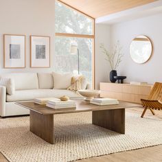 a living room filled with furniture and a large window covered in lots of natural light