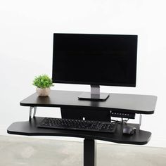 a computer desk with a monitor, keyboard and mouse sitting on it's stand