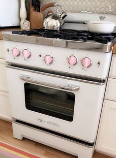 a white stove top oven sitting inside of a kitchen