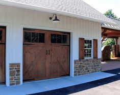 two garages with wooden doors and brick pillars