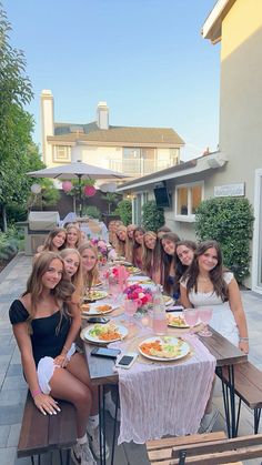 a group of women sitting at a table with plates of food