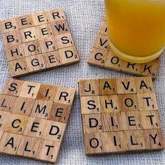 four scrabble tiles with words written on them and a glass of orange juice